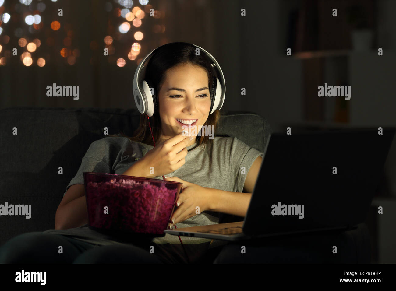 Single Woman Watching Online Tv In The Night Sitting On A Couch In
