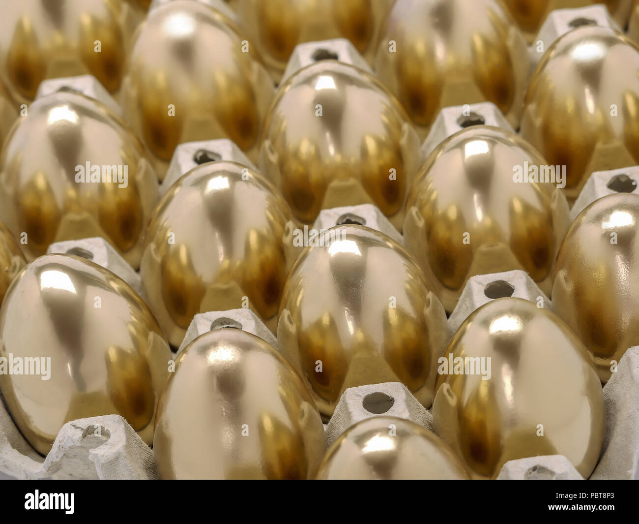 Bunch of golden eggs in egg tray shot from above Stock Photo