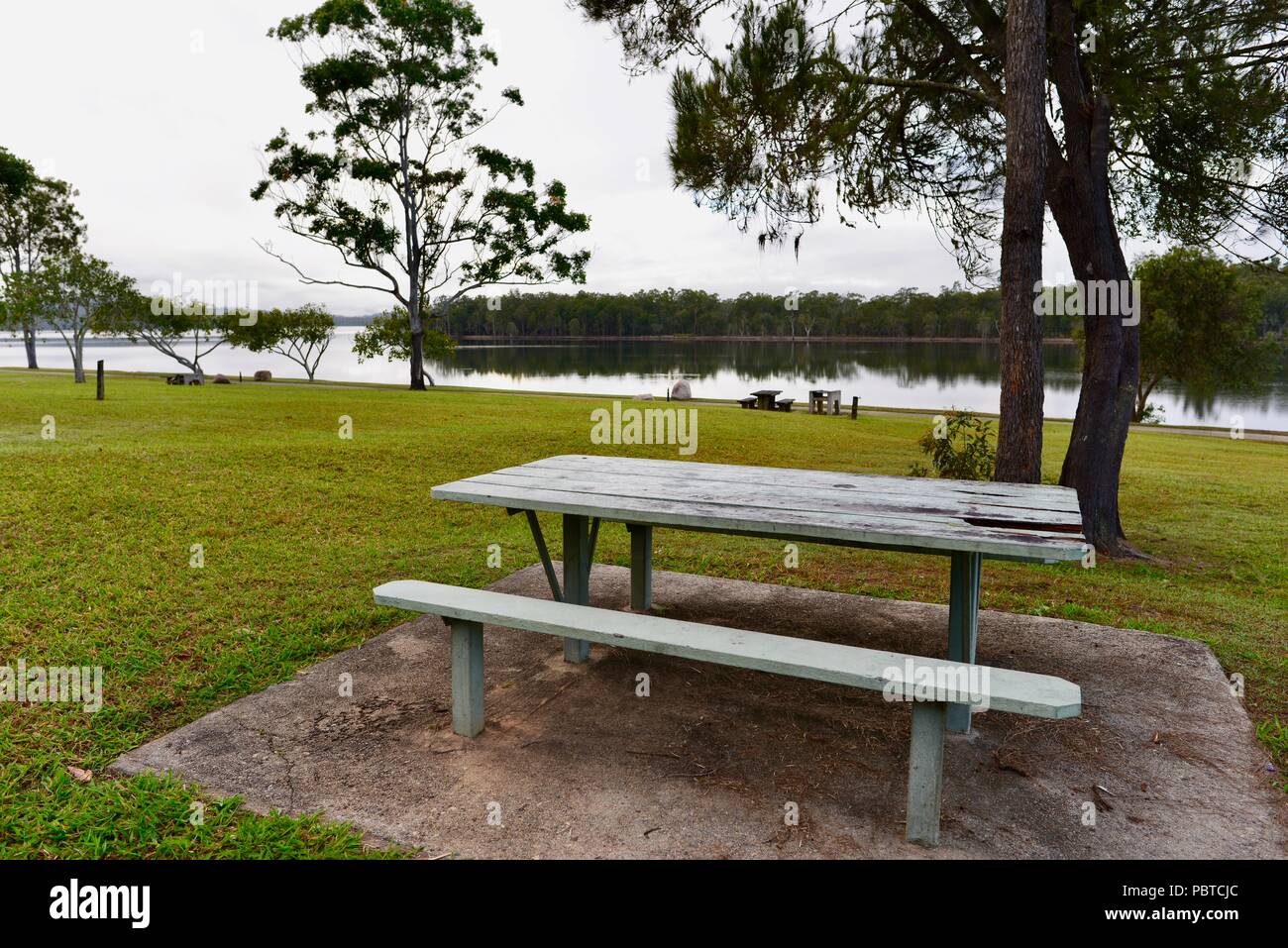 A barbeque and wooden picnic table and bench at Lake Tinaroo, Atherton Tablelands, QLD ...