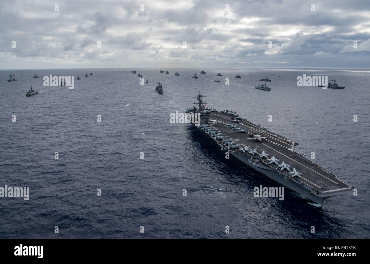 180726-N-MT837-2267 PACIFIC OCEAN (July 26, 2018) Navy ships assemble to form the multinational fleet for a photo exercise off the coast of Hawaii during the Rim of Pacific (RIMPAC) exercise, July 26. Twenty-six nations, more than 45 ships and submarines, about 200 aircraft and 25,000 personnel are participating in RIMPAC from June 27 to Aug. 2 in and around the Hawaiian Islands and Southern California. The world's largest international maritime exercise, RIMPAC provides a unique training opportunity while fostering and sustaining cooperative relationships between participants critical to ensu Stock Photo
