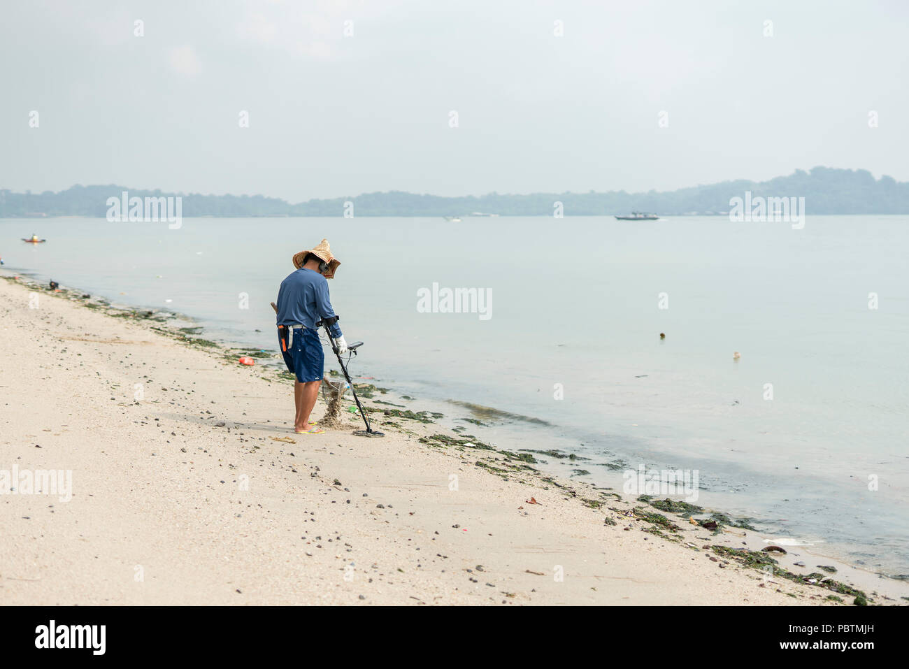 Singapore June 03 2018 Treasure hunting on the beach using metal detector Stock Photo Alamy