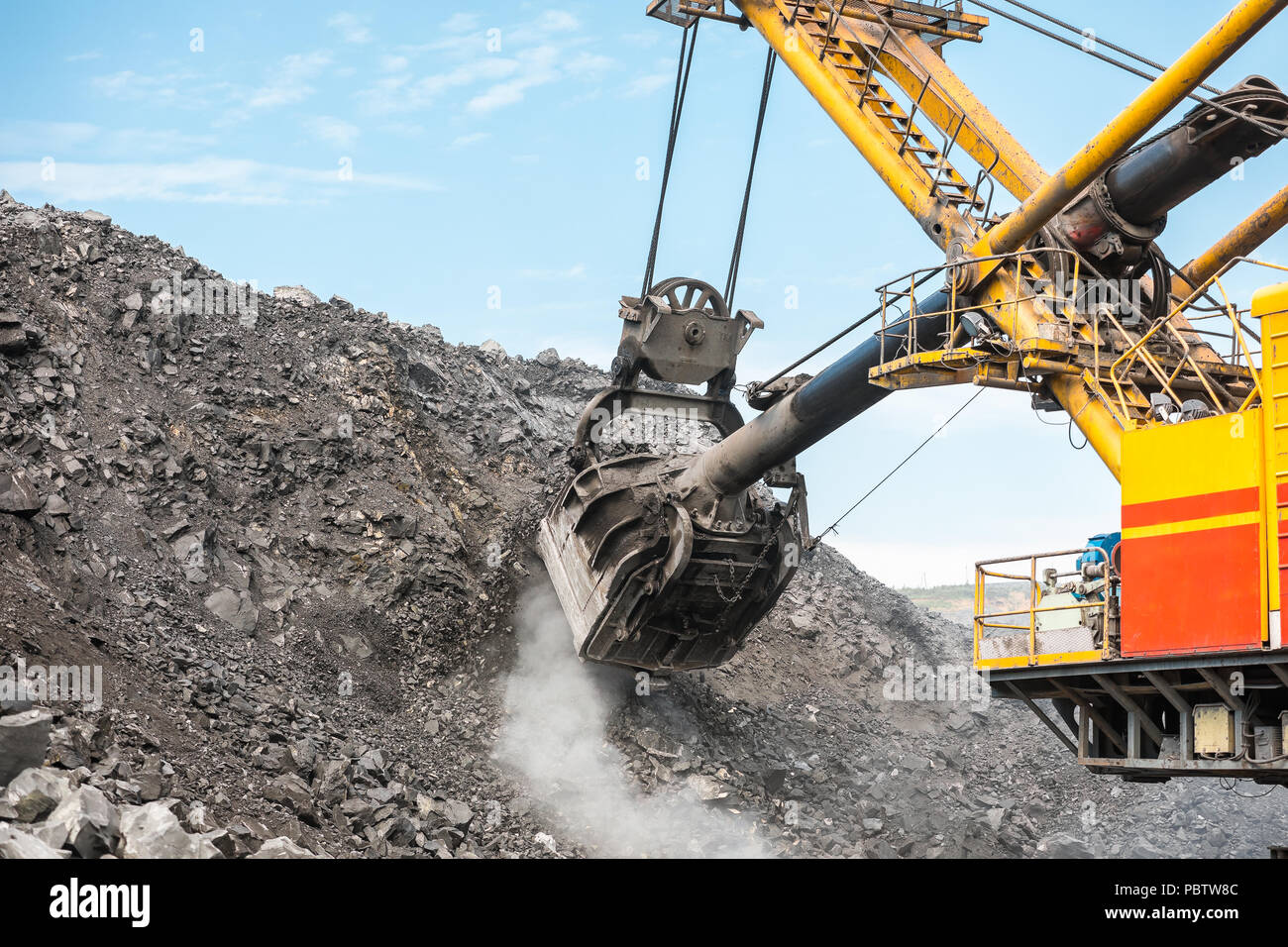 Large quarry dump truck. Loading the rock in dumper. Loading coal into body truck. Production useful minerals. Mining truck mining machinery, to transport coal from open-pit as the coal production. Stock Photo