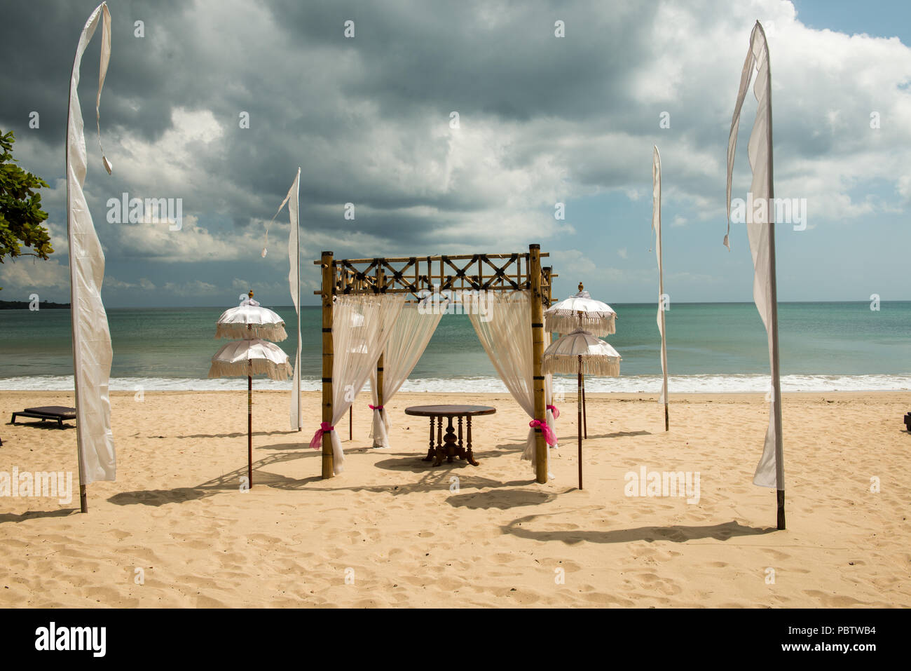 Preparations for a wedding ceremony on the beach at Jimbaran, Bali. Ominous clouds on the horizon. Stock Photo