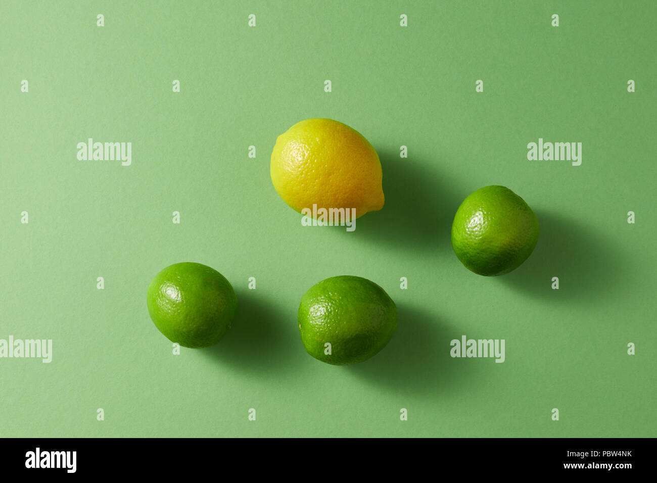Citrus fruits on a green background. Top view of a group of green limes ...