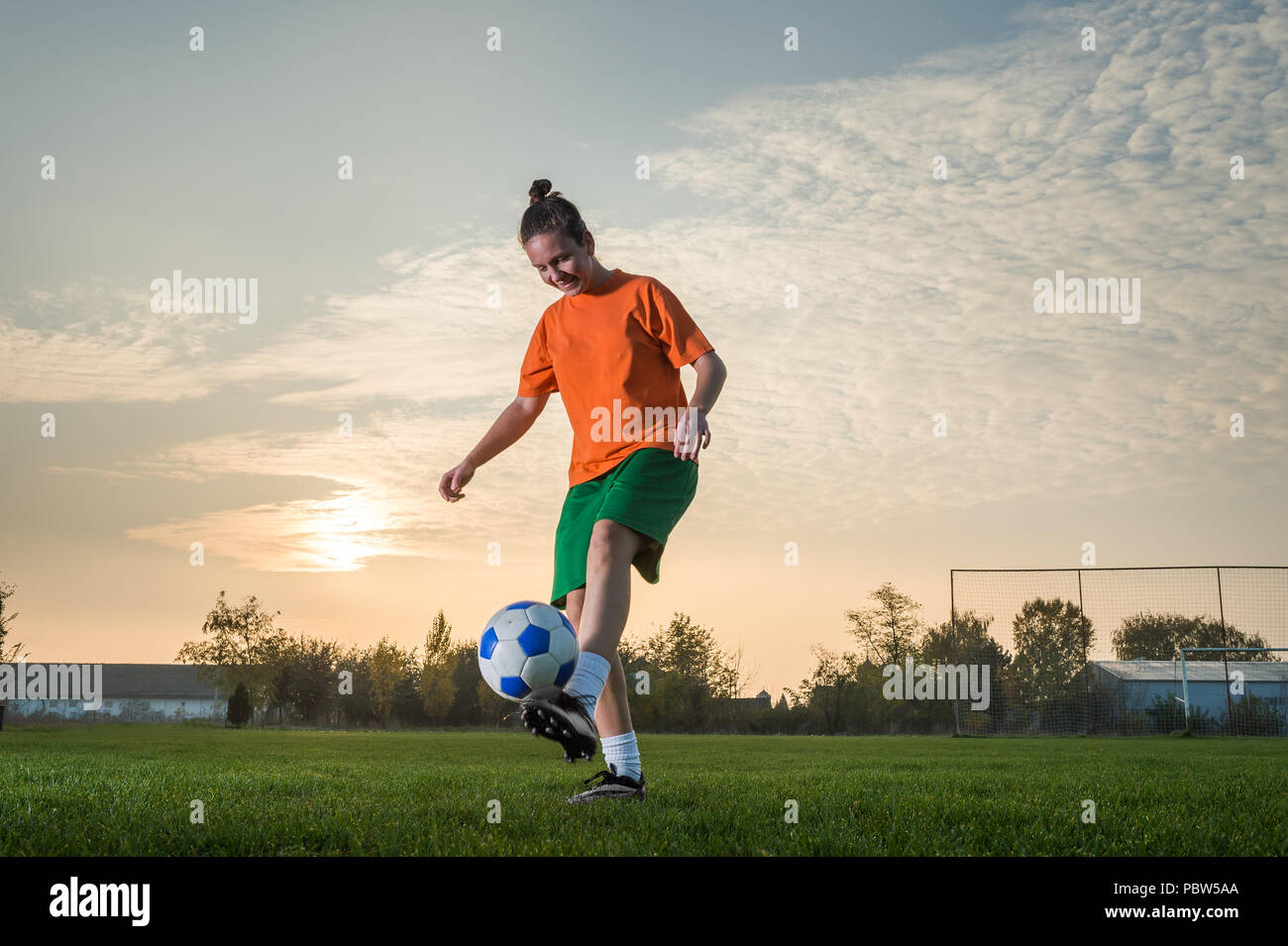 young woman kicking soccer ball Stock Photo - Alamy