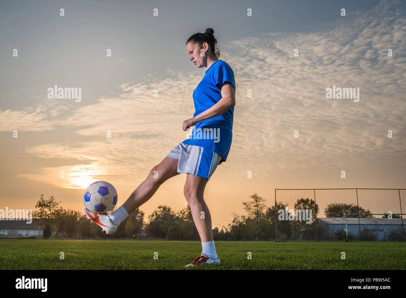 young woman kicking soccer ball Stock Photo - Alamy