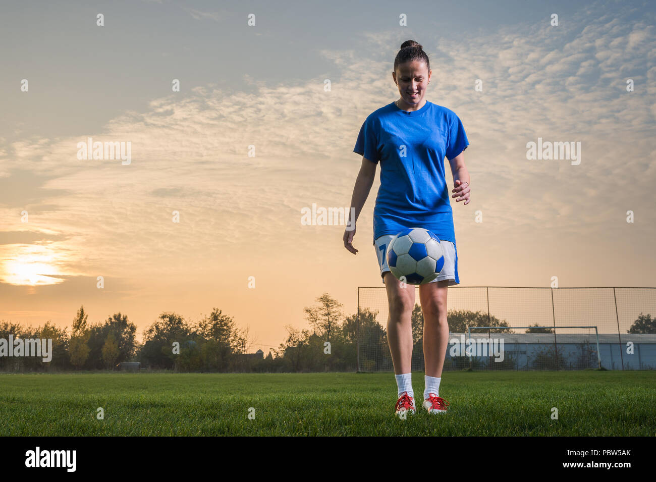 young woman kicking soccer ball Stock Photo - Alamy