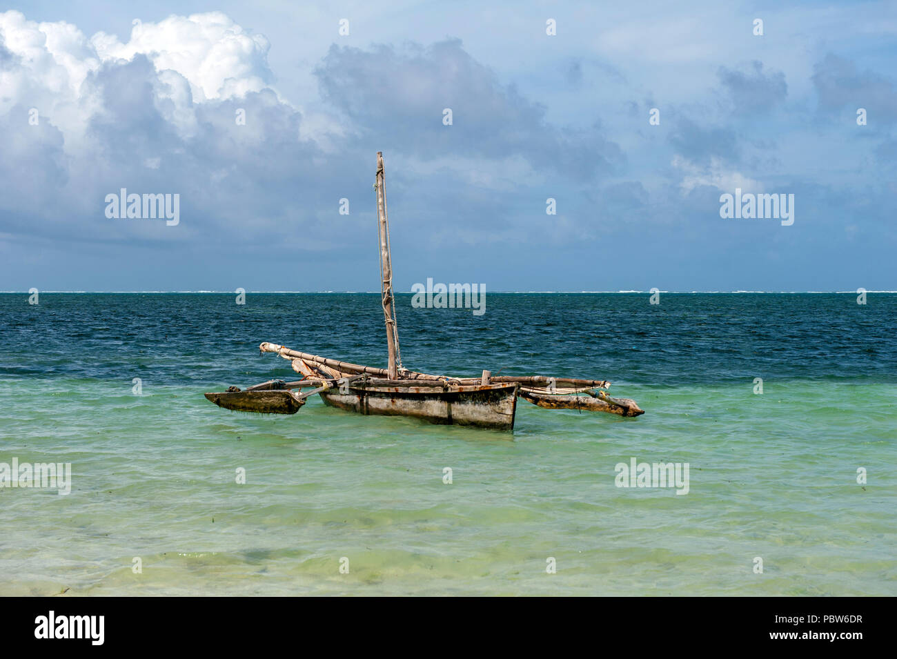 An old wooden fishing boat with nets floats on the ocean with sunset in  background. Zanzibar, Tanzania. Africa Stock Photo - Alamy