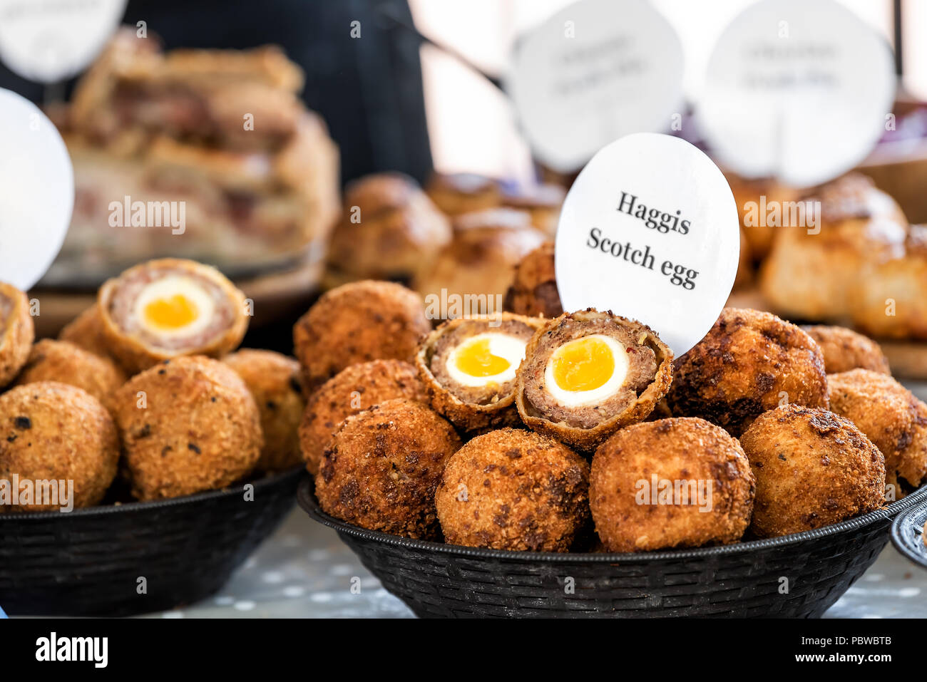 Closeup bowl of Haggis Scotch deep fried eggs with sign in market