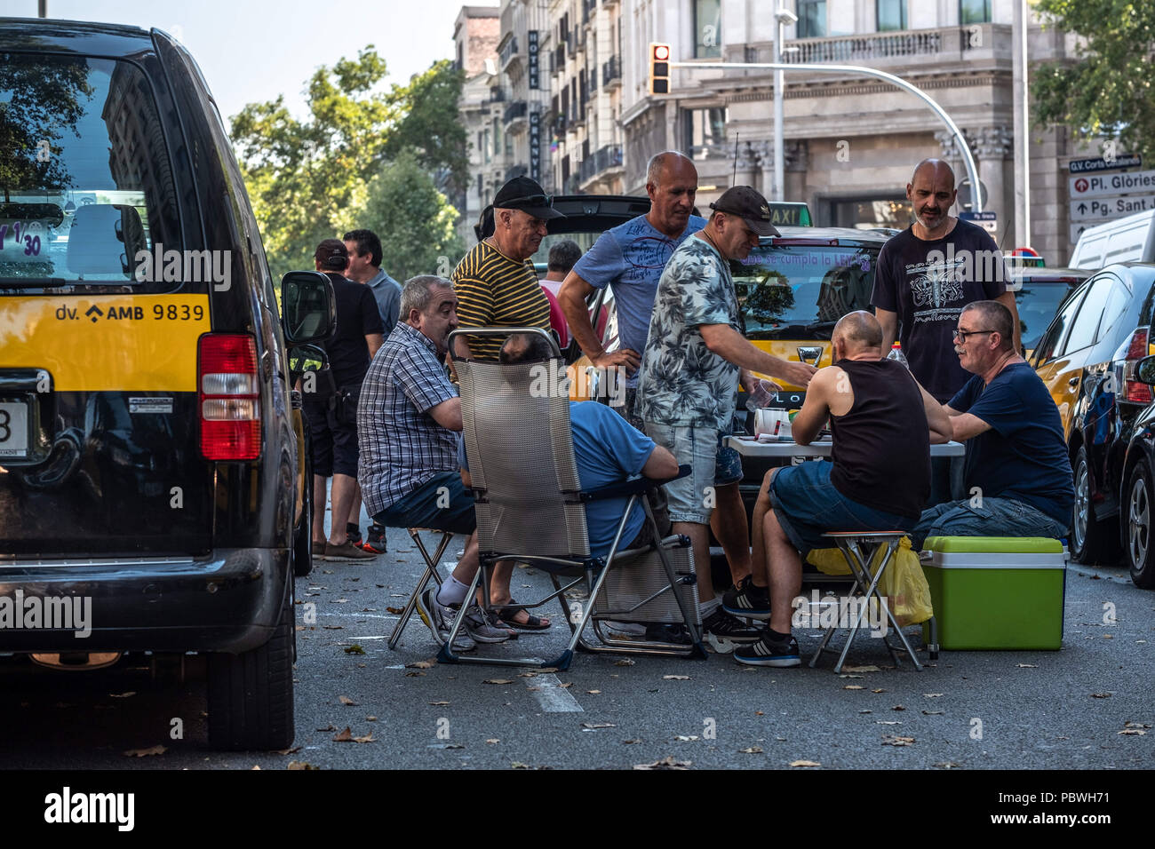 Barcelona, Catalonia, Spain. 30th July, 2018. A group of taxi drivers seen having breakfast next to their vehicles on the Gran VÃ-a de Barcelona. The taxi drivers strike enters its third day and extends through the main Spanish cities. The taxi sector is not willing to lose this battle in favor of the new Uber and Cabify platforms. Credit: Paco Freire/SOPA Images/ZUMA Wire/Alamy Live News Stock Photo