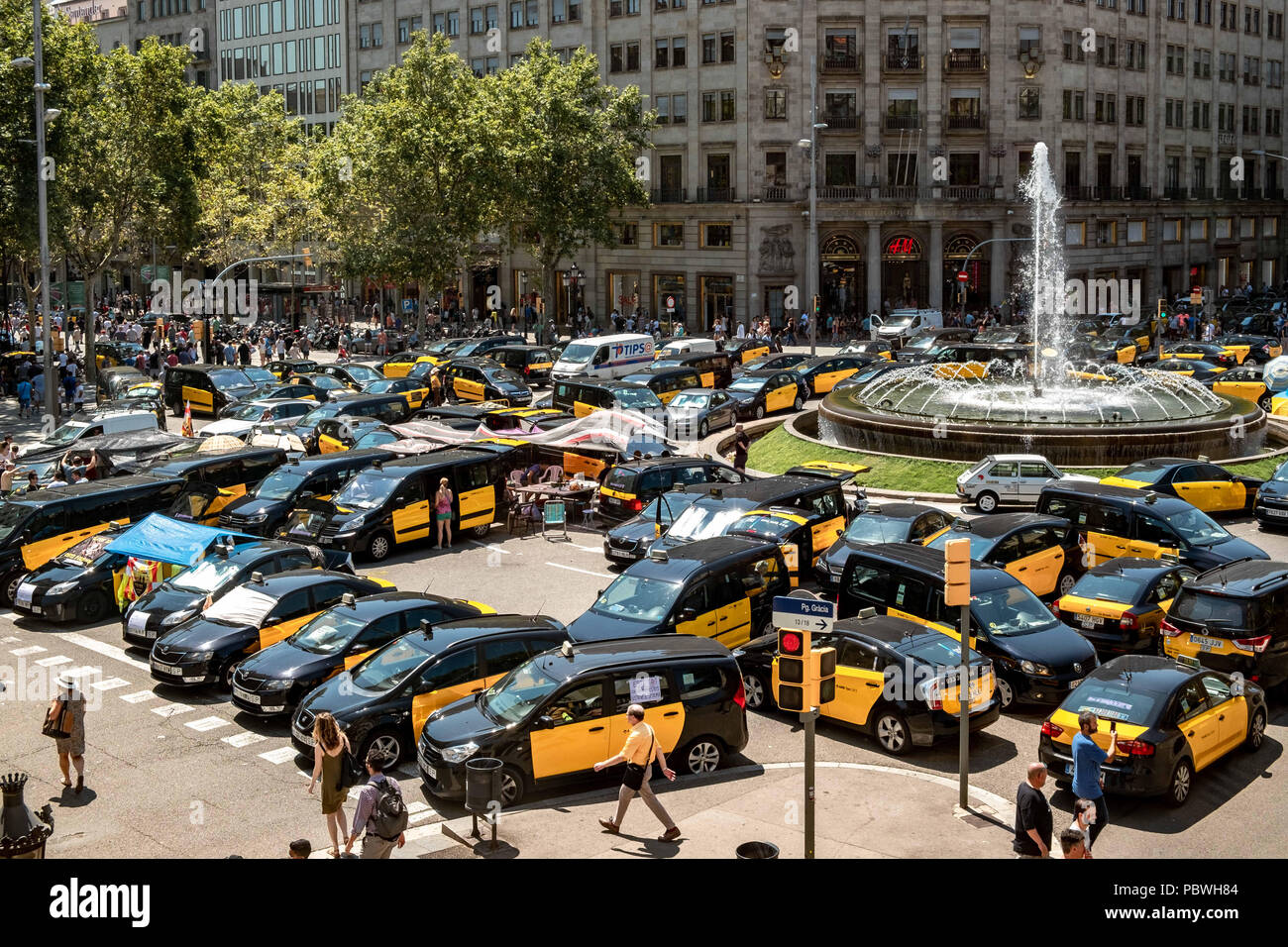Barcelona, Catalonia, Spain. 30th July, 2018. A group of taxis seen parked at the Gran VÃ-a intersection on Paseo de Gracia. The taxi drivers strike enters its third day and extends through the main Spanish cities. The taxi sector is not willing to lose this battle in favor of the new Uber and Cabify platforms. Credit: Paco Freire/SOPA Images/ZUMA Wire/Alamy Live News Stock Photo