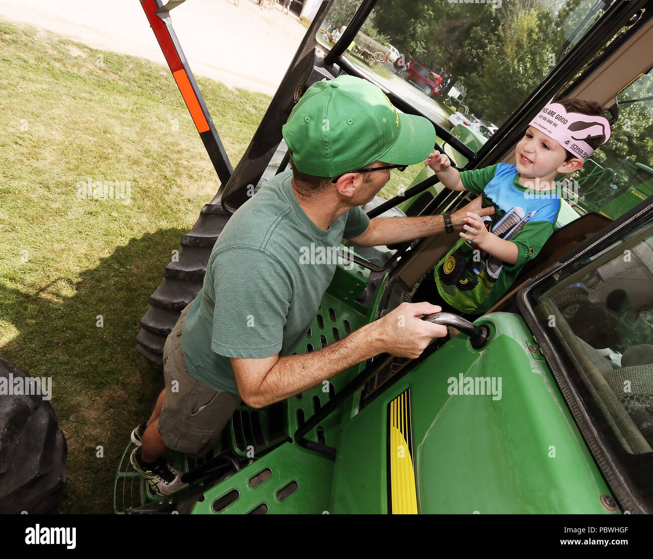 Davenport, Iowa, USA. 29th July, 2018. Bryan Miller, left and his son Carson Miller explore the John Deere 9220 Tractor during the Open Farm Day at the Robb and Jennifer Ewoldt farm located west of Davenport, Iowa Sunday, July 29, 2018. Credit: Kevin E. Schmidt/Quad-City Times/ZUMA Wire/Alamy Live News Stock Photo