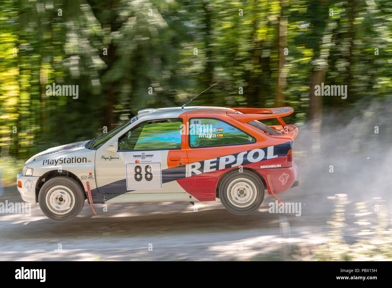 A Ford Escort Cosworth rally car takes to the air over a jump in the rally stages at the Goodwood Festival of Speed 2018 Stock Photo