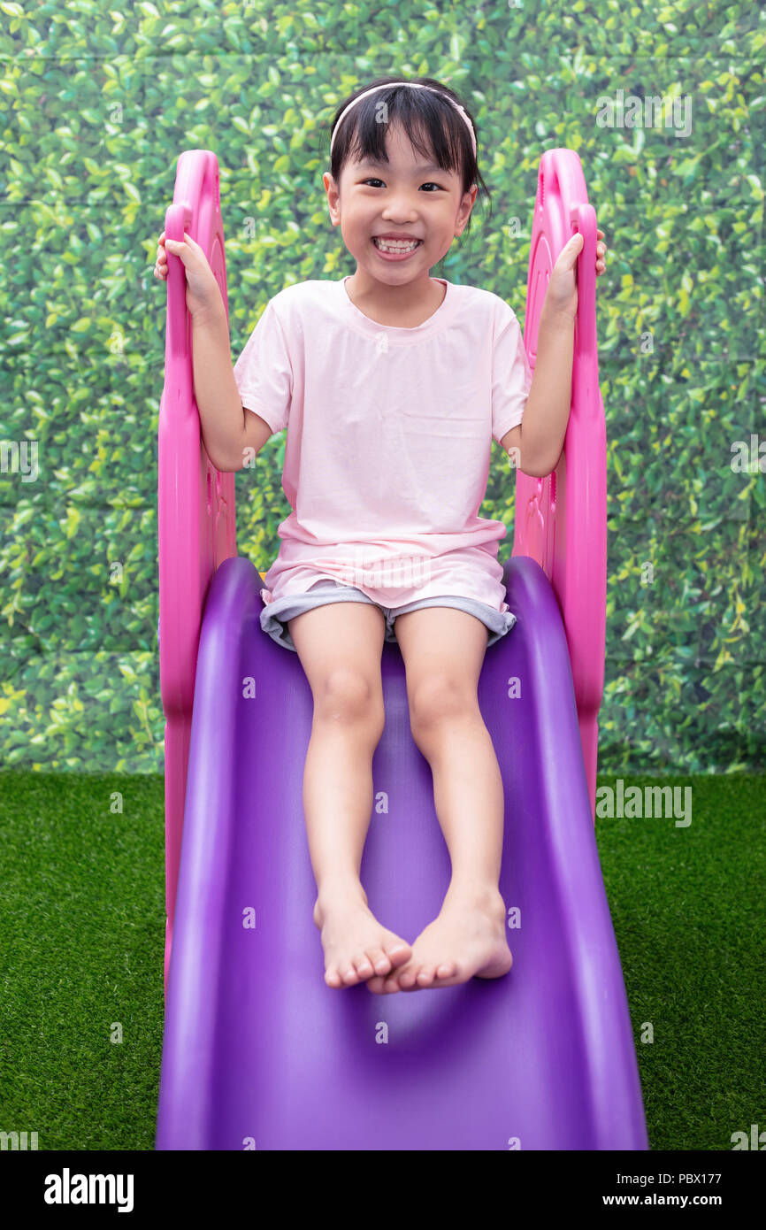 Asian Chinese Little Girl Playing on the slide at outdoor playground ...