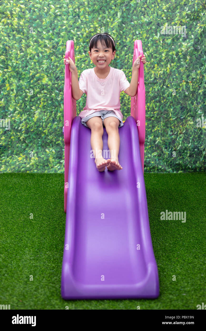 Asian Chinese Little Girl Playing on the slide at outdoor playground ...