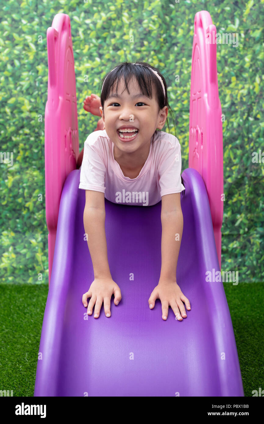 Asian Chinese Little Girl Playing on the slide at outdoor playground ...