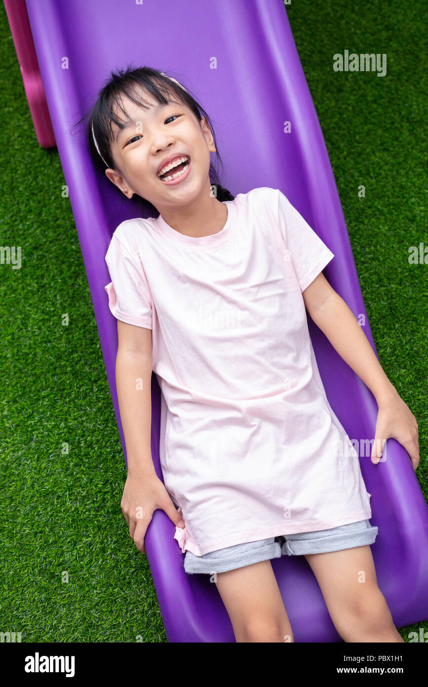 Asian Chinese Little Girl Playing on the slide at outdoor playground ...