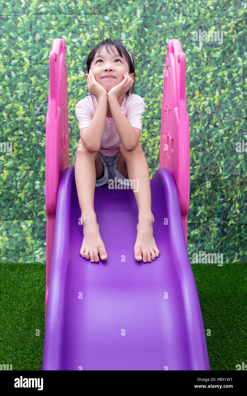 Asian Chinese Little Girl Playing on the slide at outdoor playground ...