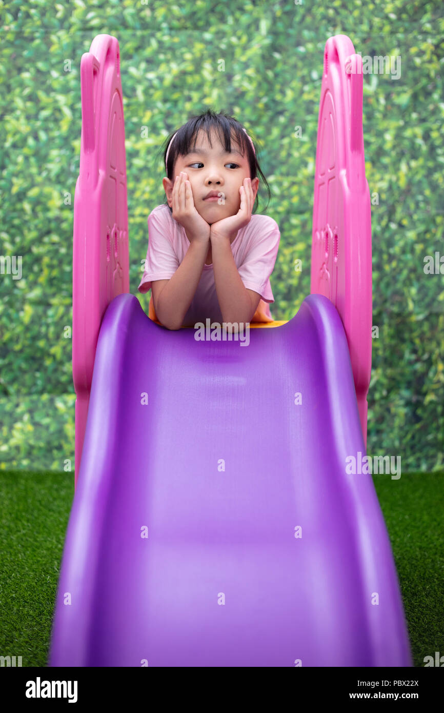 Asian Chinese Little Girl Playing on the slide at outdoor playground ...