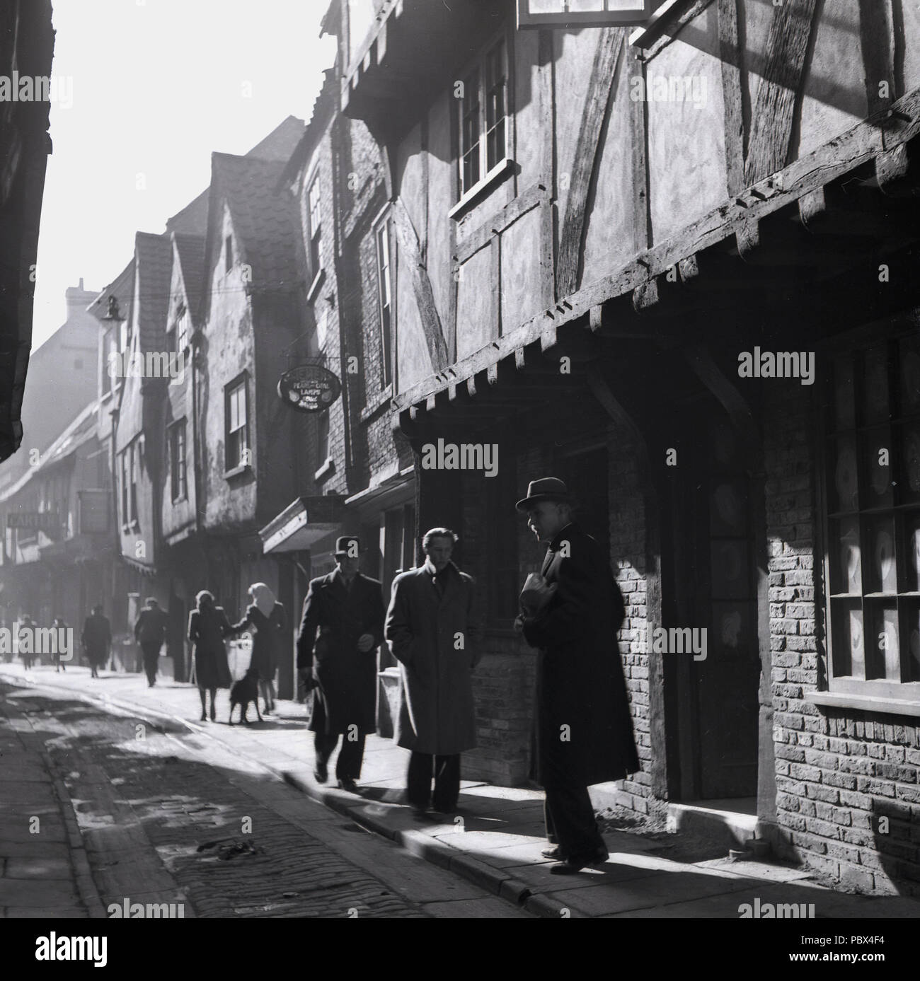 1950s, a view of the Shambles, York, England, UK, an ancient medieval narrow cobbled street of over-hanging timber-framed buildings. The Shambles was for centuries a street of butchers and famous for its meat and is considered the most medieval street in England. Stock Photo