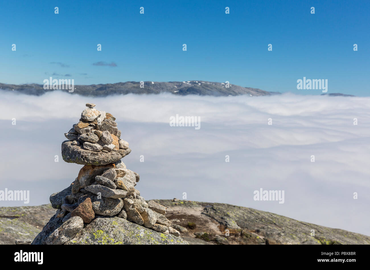 Norwegian stone pyramid with a cloud sea at background Stock Photo