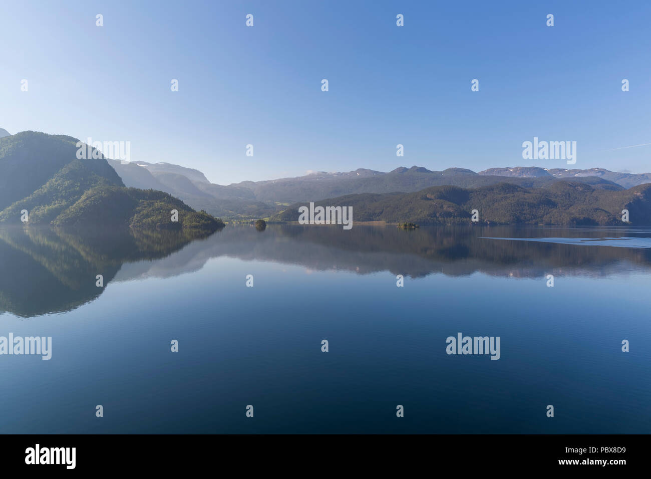 Beautiful reflection of mountains in the waters of Suldalsvatnet lake Stock Photo