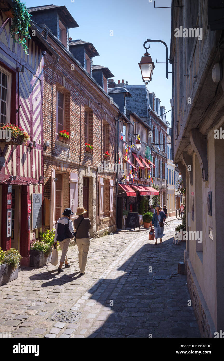 Walkers in a historic cobbled street in Honfleur, Normandy, France Stock Photo