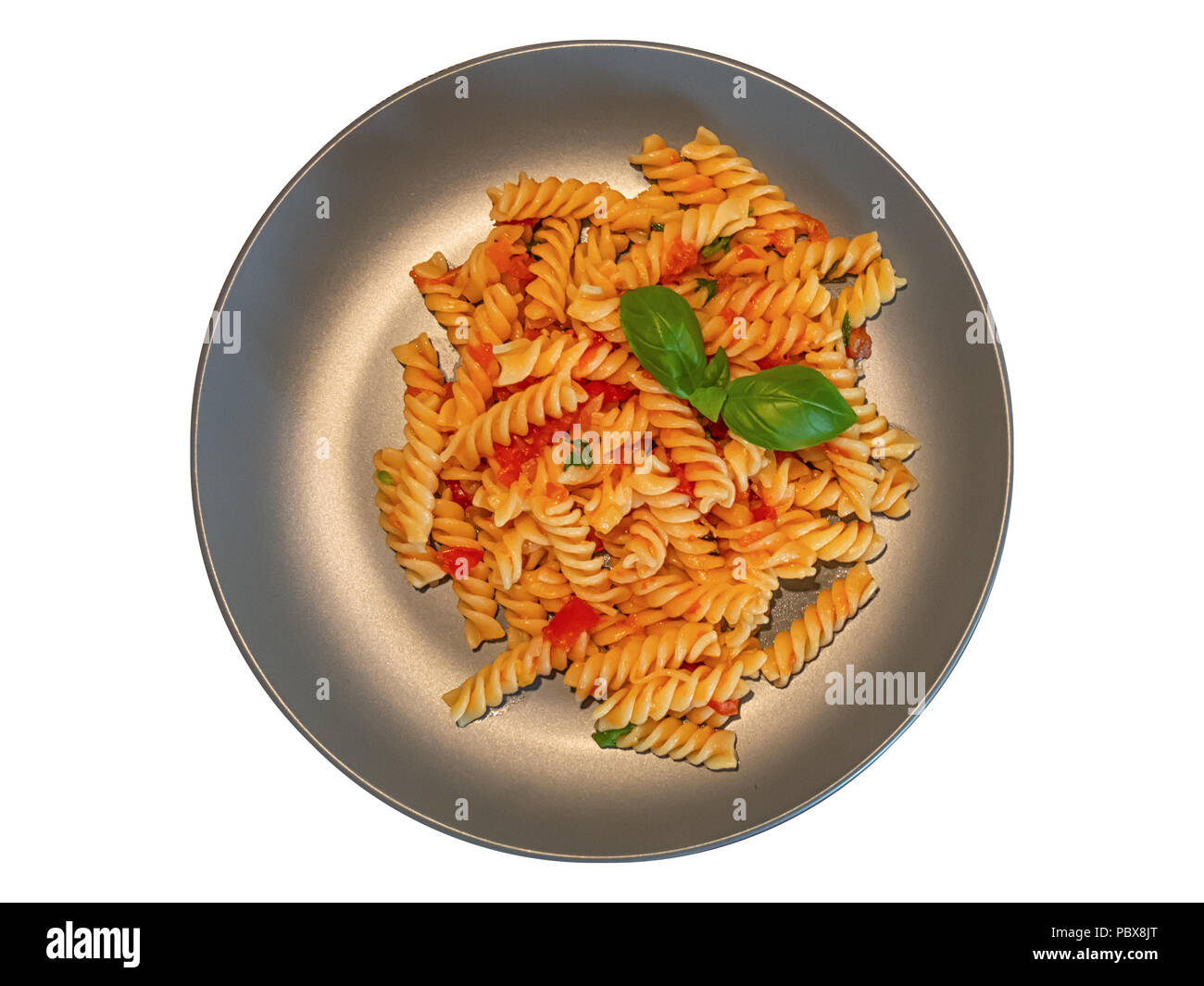 Pasta Fusilli with tomato sauce and fresh basil on a gray plate (View from above) isolated on white background Stock Photo