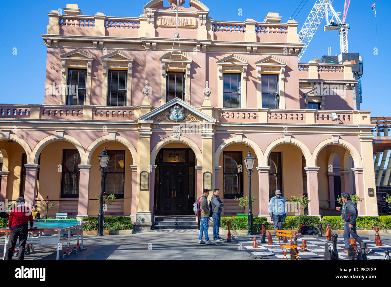 Asian men playing street chess outside Parramatta town hall in centenary square,Western Sydney,Australia Stock Photo