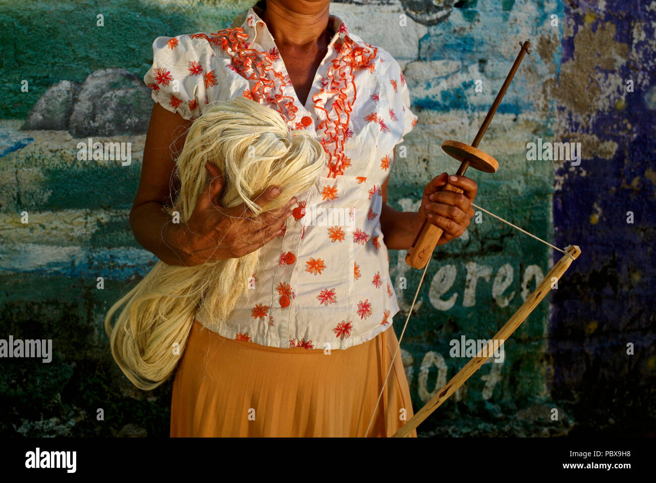 Kankuamo indigenous woman holding the carrumba knitting tool and the fique fiber, also known as maguey, used in the creation and knitting of the iconi Stock Photo