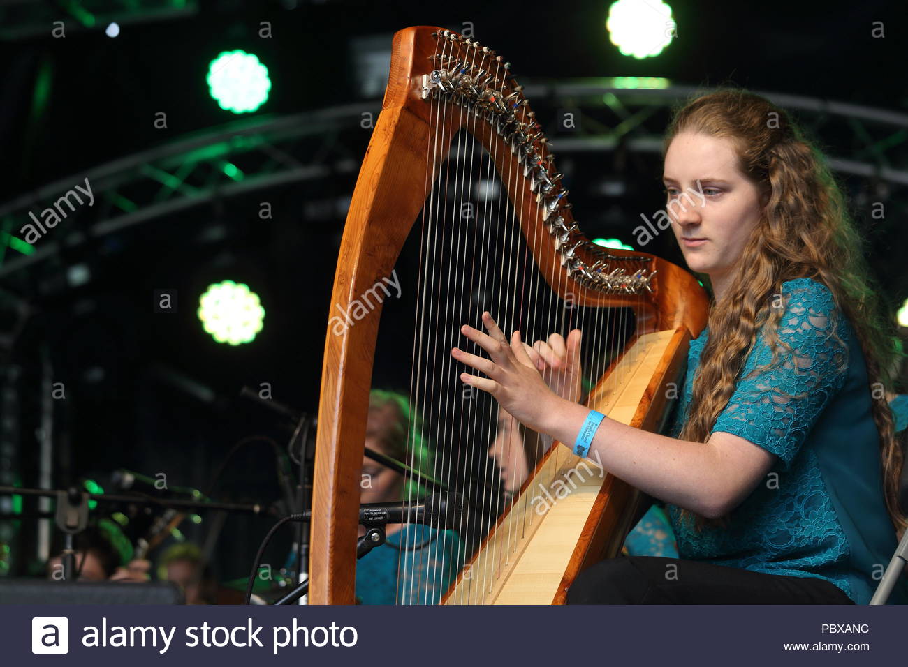 Young woman plucking harp at fleadh cheoil hires stock photography and