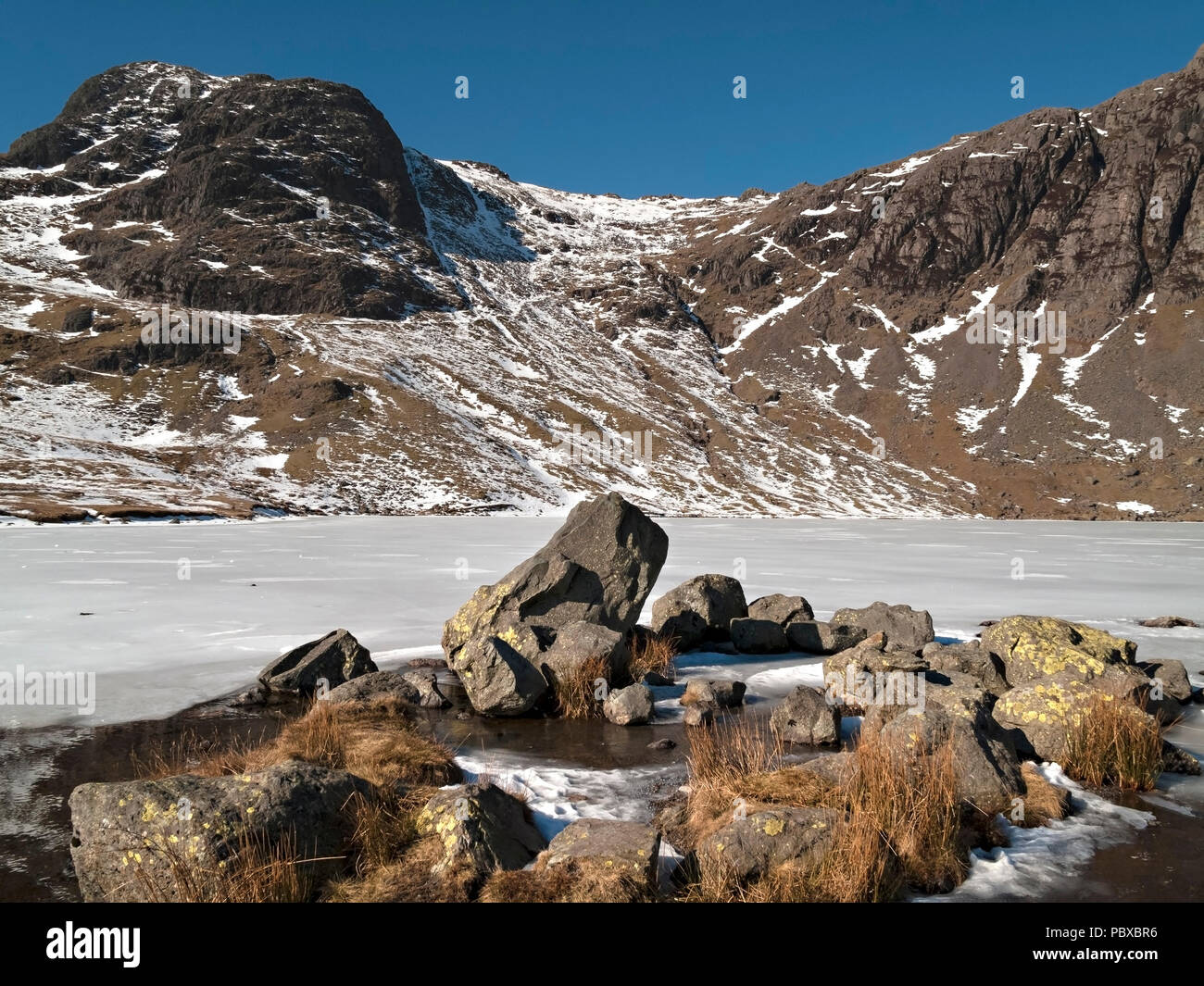 Harrison Stickle and frozen stickle tarn in Winter snow, Langdale Pikes, Langdale, English Lake District National Park, Cumbria, England, UK Stock Photo