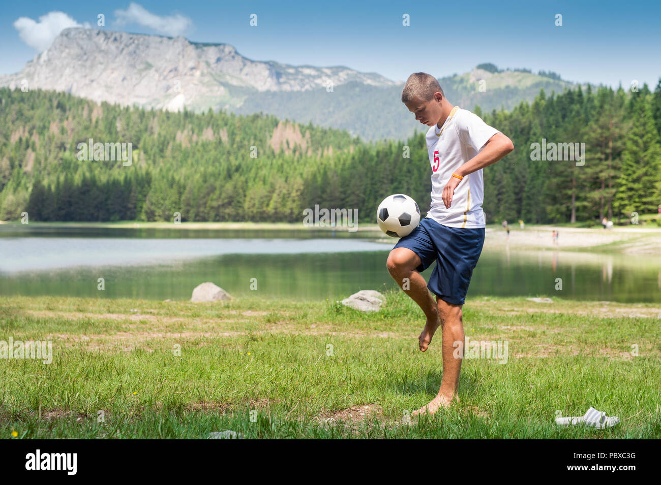 Soccer player juggles the ball in nature Stock Photo