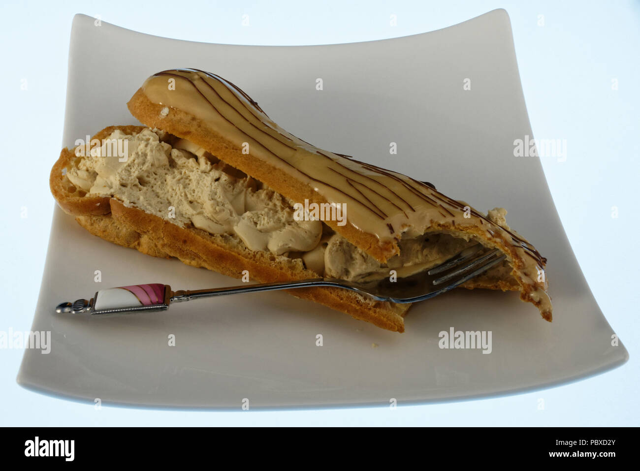 A delicious eclair with a bite out of the end Stock Photo