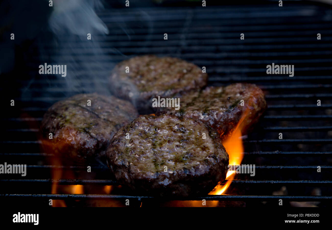 beefburgers being cooked on a BBQ Stock Photo