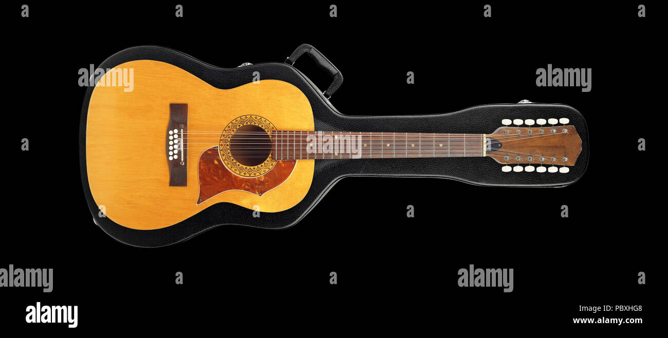 Musical instrument - Vintage twelve-string acoustic guitar from above on a hard case hard case isolated on a black background. Stock Photo