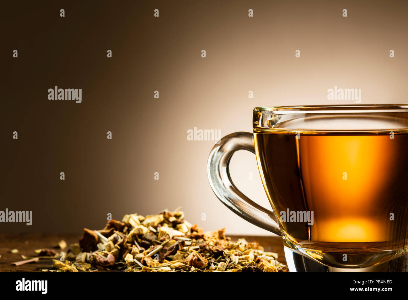 https://c8.alamy.com/comp/PBXNED/closeup-of-glass-cup-of-tea-with-herbal-on-wooden-table-PBXNED.jpg