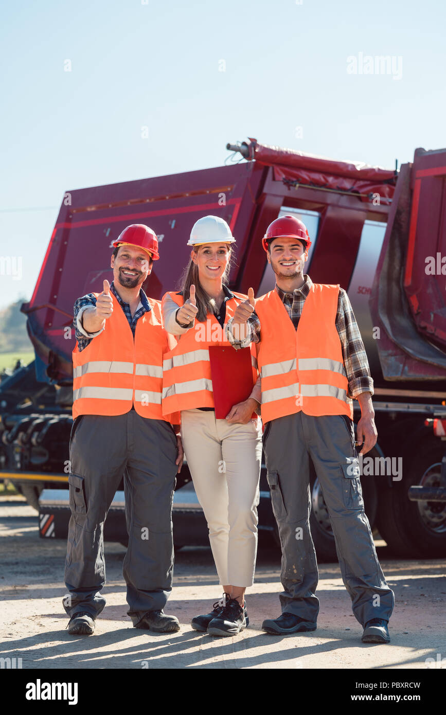Colleagues in a freight forwarding company giving thumbs up Stock Photo
