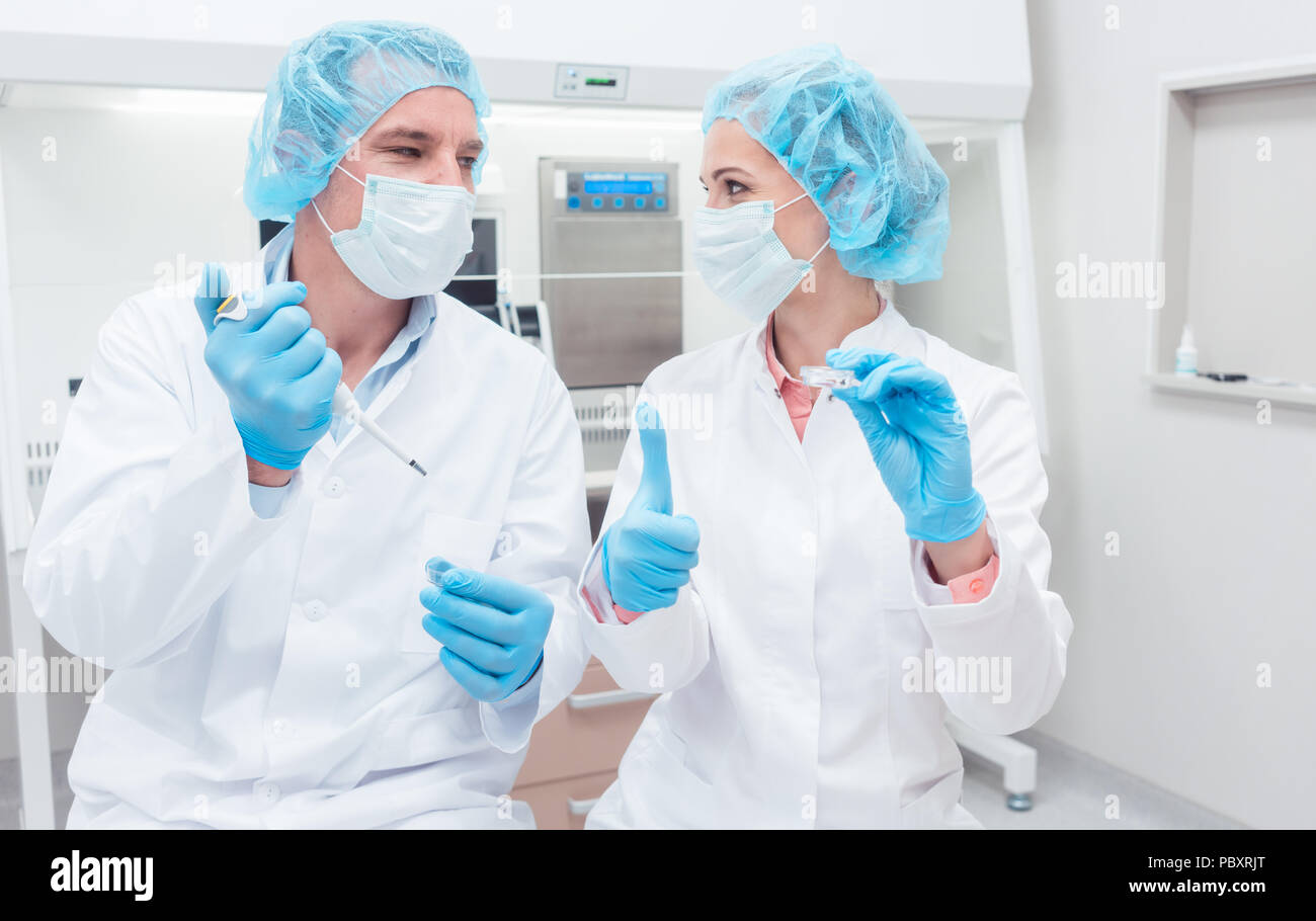 Scientists in biotech lab with pipette and sample dish Stock Photo