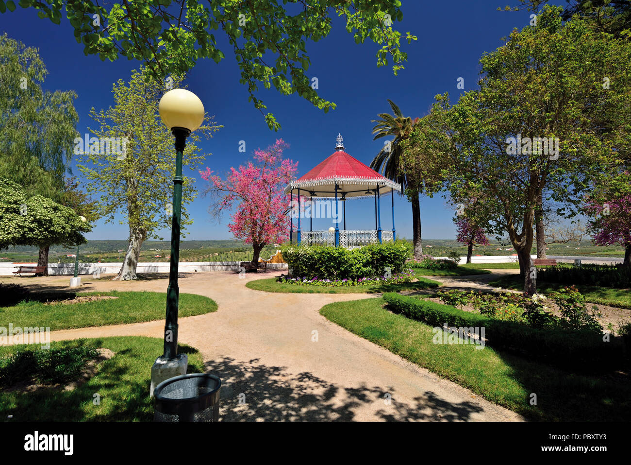 Romantic city park with green areas, trees and music pavilion Stock Photo