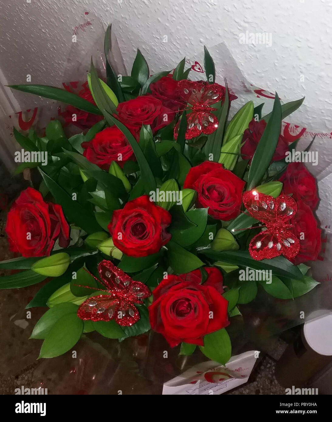 Bunch of red Valentines roses displayed against a wall Stock Photo