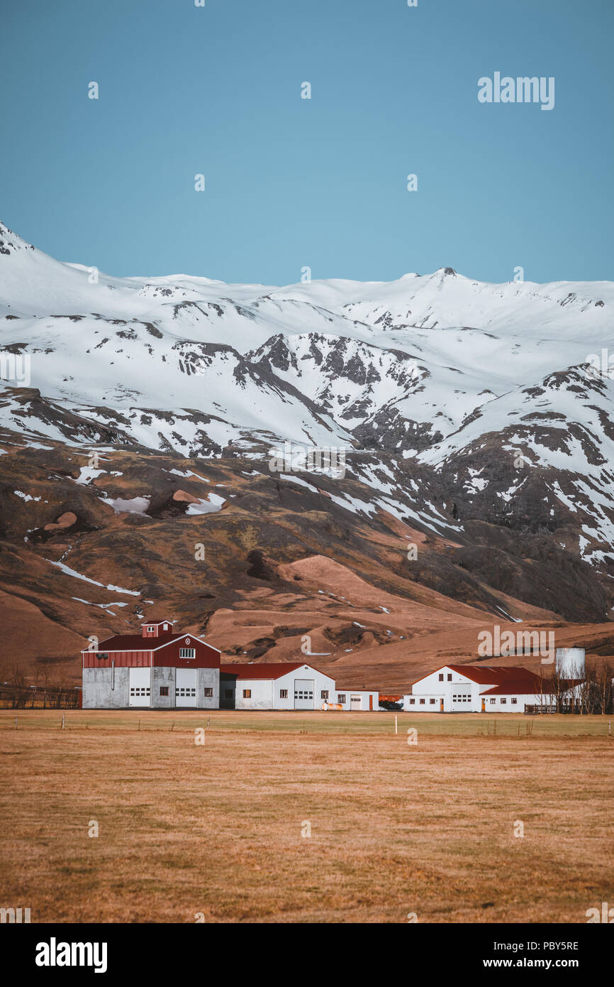 Typical Icelandic landscape with white houses red roof against mountains in small village in South Iceland. Stock Photo