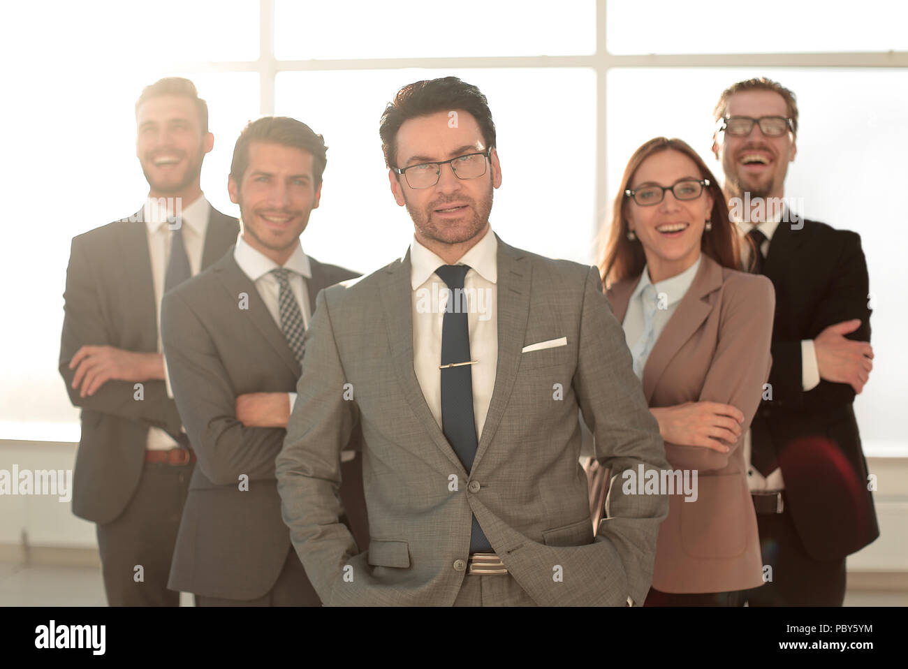 Happy business team with arms crossed at the office Stock Photo - Alamy