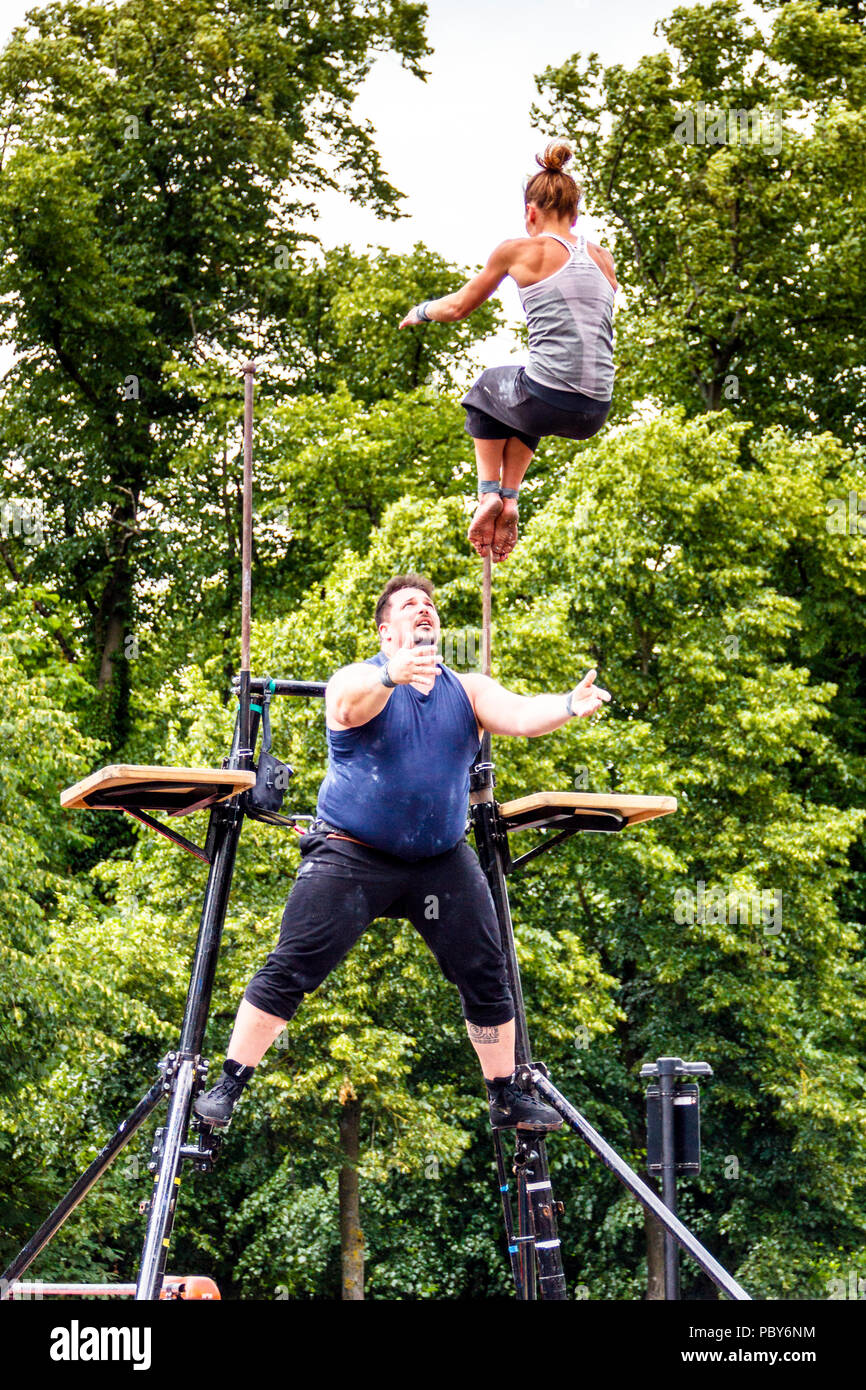 Male and female trapeze artists at the 'Fair in the Square', an annual festival in Pond Square and South Grove, Highgate Village, London, UK Stock Photo