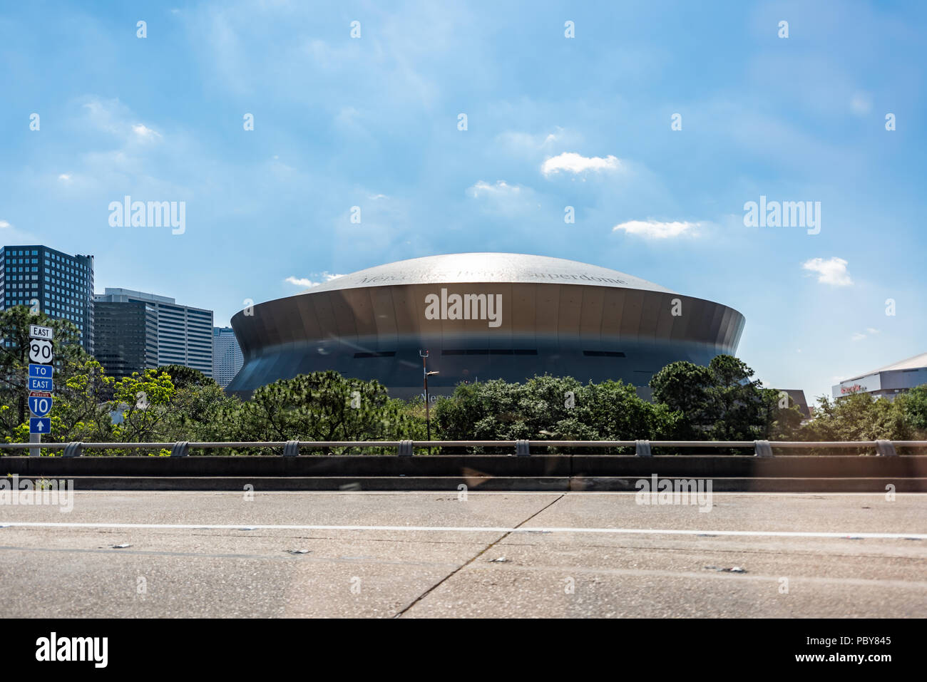 New Orleans, USA - April 23, 2018: Famous Mercedes-Benz Superdome stadium in Louisiana with road signs, sunny day Stock Photo