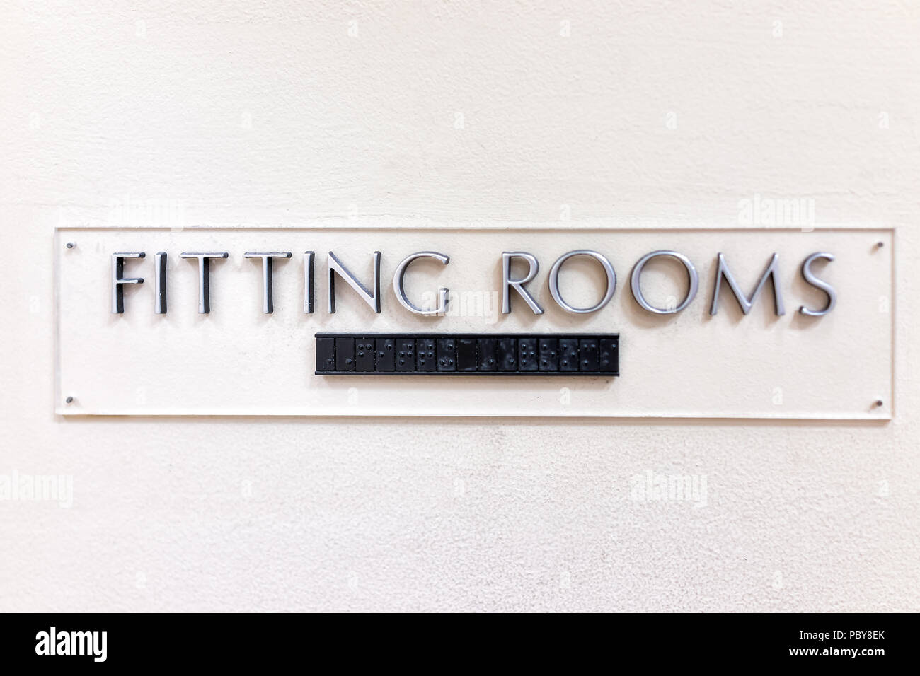 Fitting Room sign closeup in mall store shop retail clothing changing door entrance with nobody on wall, braille Stock Photo