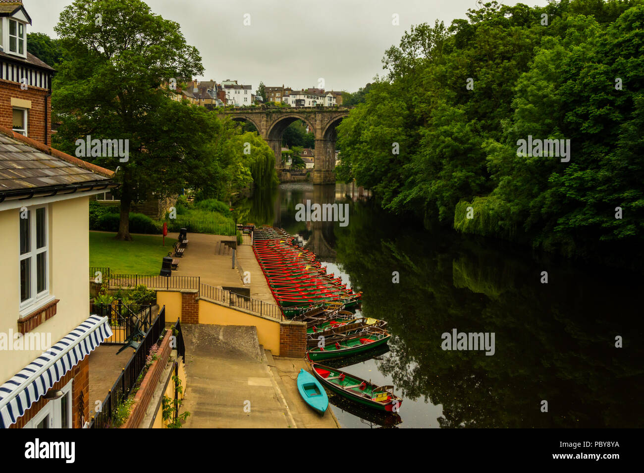 View of the Nidd River, rowing boats, houses and forest in Knaresborough. Beautiful old bridge in a cloudy day. Lovely village of england, UK. Stock Photo