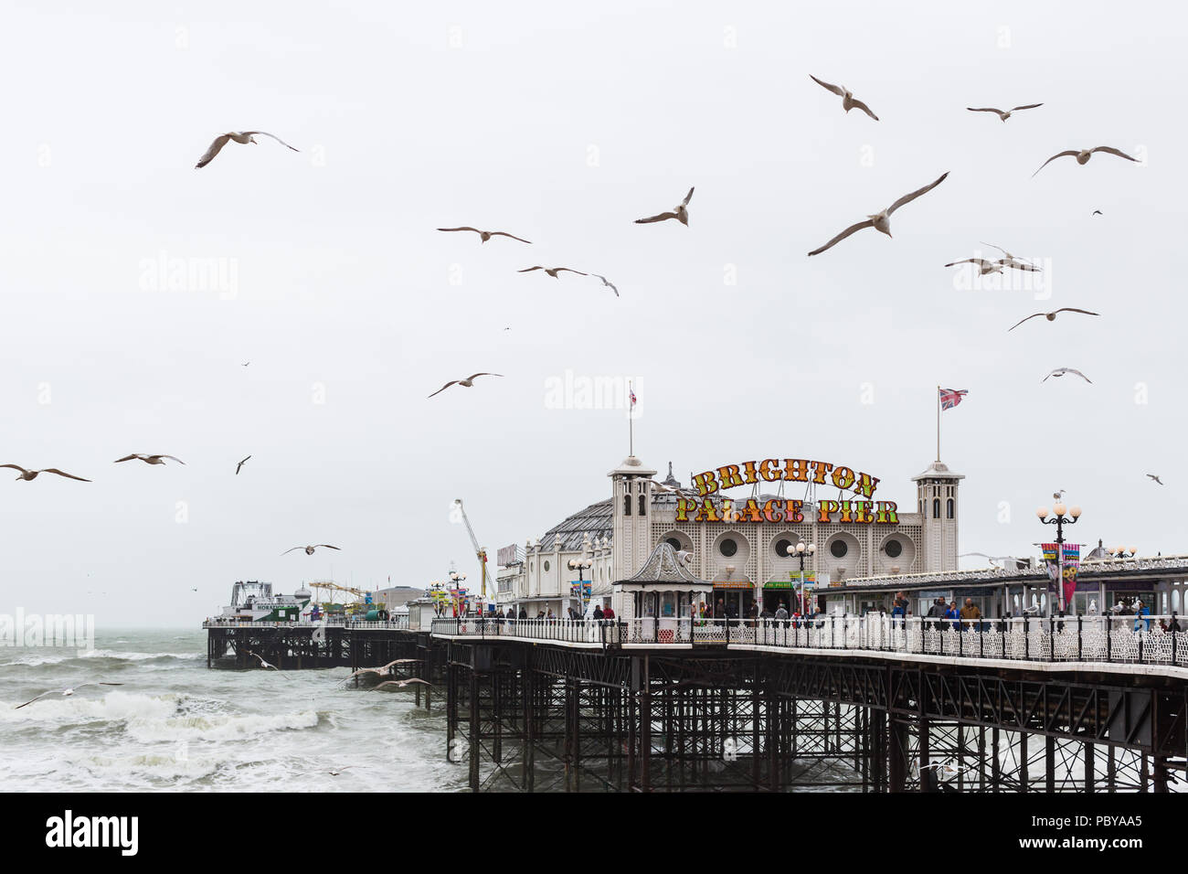 Seagulls and stormy seas on a miserable summer's day at Brighton Palace Pier Stock Photo
