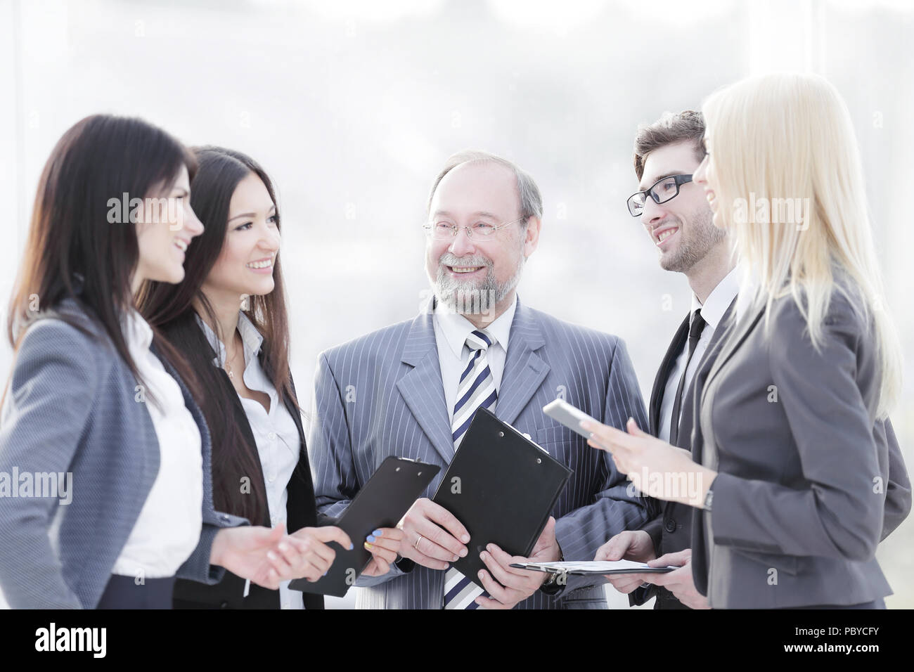 close up.a business team standing talking in the office Stock Photo - Alamy