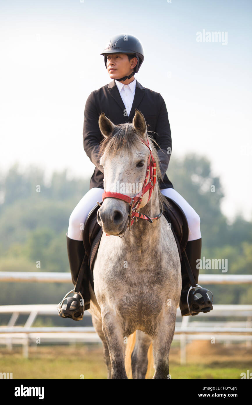 Young Chinese man riding horse Stock Photo - Alamy